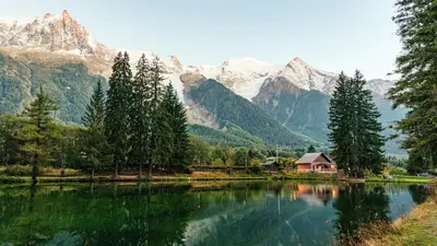 a lake with a house and mountains in the background at Apartment Grepon 6 Incredible Mont Blanc View Chamonix in Chamonix-Mont-Blanc