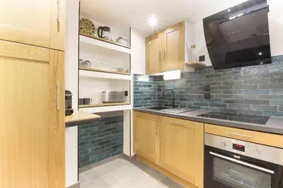 a small kitchen with wooden cabinets and a microwave at Bellevarde Apt - Newly Renovated - Central - Beside TMB start/end in Les Houches