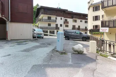 a parking lot with a blue parking meter next to a building at Bellevarde Apt - Newly Renovated - Central - Beside TMB start/end in Les Houches