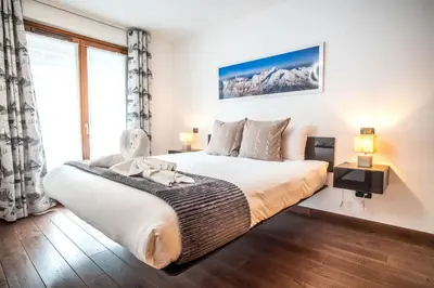 a bedroom with a large bed and a large window at Les Alpes 3 - Central - Rénové - Vue sur la chaîne du Mont-Blanc in Chamonix-Mont-Blanc