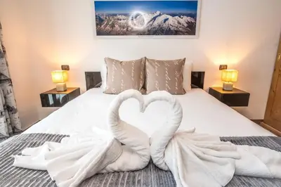 two white swans making a heart on a bed at Les Alpes 3 - Central - Rénové - Vue sur la chaîne du Mont-Blanc in Chamonix-Mont-Blanc