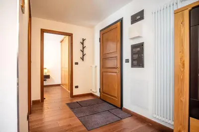a hallway with a door and a rug at Les Alpes 3 - Central - Rénové - Vue sur la chaîne du Mont-Blanc in Chamonix-Mont-Blanc