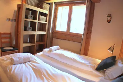 two beds in a room with a window at Apartment Planards Centre Chamonix foot of the Planards Slopes in Chamonix-Mont-Blanc