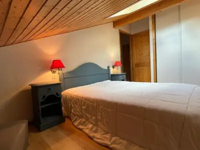 a bedroom with a bed and two lamps on two tables at Appartement mansardé 2 pièces avec piscine et wifi - FR-1-629-124 in Samoëns