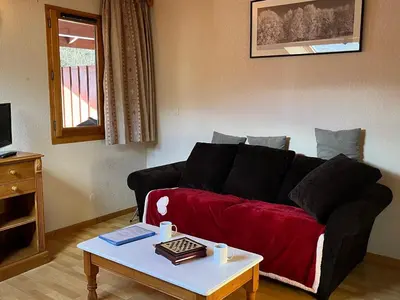 a living room with a couch and a coffee table at Appartement mansardé 2 pièces avec piscine et wifi - FR-1-629-124 in Samoëns