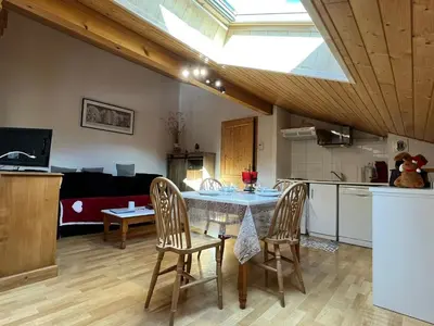 a kitchen and dining room with a table and chairs at Appartement mansardé 2 pièces avec piscine et wifi - FR-1-629-124 in Samoëns