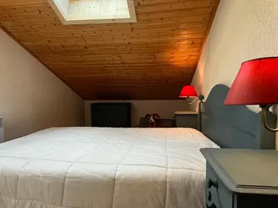 a bedroom with a white bed and two lamps at Appartement mansardé 2 pièces avec piscine et wifi - FR-1-629-124 in Samoëns