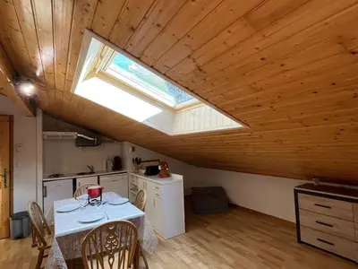 a kitchen with a white table and a skylight at Appartement mansardé 2 pièces avec piscine et wifi - FR-1-629-124 in Samoëns