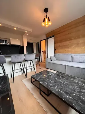 a living room with a couch and a table at Vue Mont blanc, ski et village in Combloux