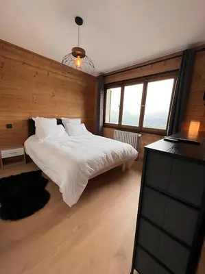 a bedroom with a white bed and a television at Vue Mont blanc, ski et village in Combloux