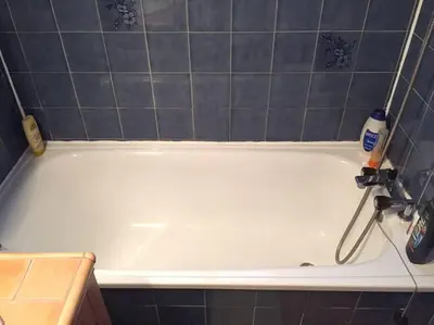 a white bath tub in a bathroom with a tile wall at Chamonix centre - 2 pièces 32 m2 in Chamonix-Mont-Blanc