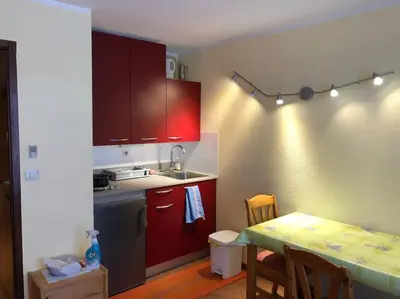 a kitchen with red cabinets and a table with a tableablish at Chamonix centre - 2 pièces 32 m2 in Chamonix-Mont-Blanc