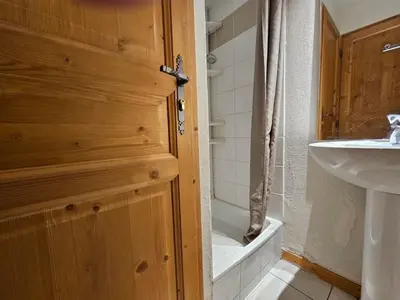 a bathroom with a wooden door and a sink at Le grand panorama appartement 2 chambres 4 adultes 2 enfants in Saint-Gervais-les-Bains