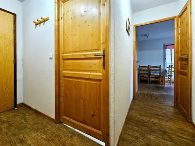 a hallway with a wooden door in a room at Le grand panorama appartement 2 chambres 4 adultes 2 enfants in Saint-Gervais-les-Bains