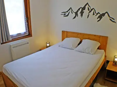 a bedroom with a bed with a mountain decal on the wall at Appartement rénové avec terrasse et parking, fibre incluse - FR-1-629-127 in Samoëns