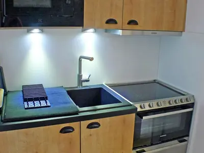 a kitchen with a sink and a stove at Appartement rénové avec terrasse et parking, fibre incluse - FR-1-629-127 in Samoëns