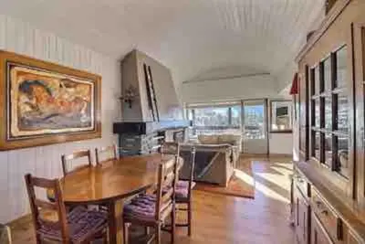 a dining room with a table and chairs in a room at superbe appartement avec vue sur montagnes, calme in Megève