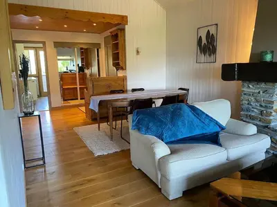 a living room with a white couch and a table at superbe appartement avec vue sur montagnes, calme in Megève