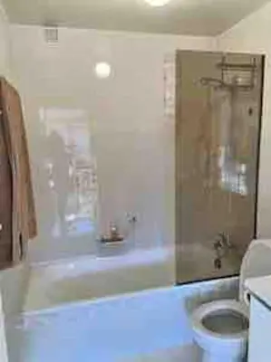 a bathroom with a white tub and a toilet at superbe appartement avec vue sur montagnes, calme in Megève