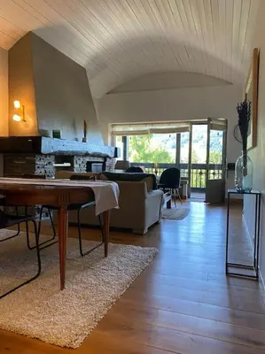 a living room with a table and a couch at superbe appartement avec vue sur montagnes, calme in Megève