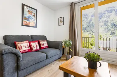 a living room with a couch and a window at Apartment Le Panoramic in Chamonix-Mont-Blanc