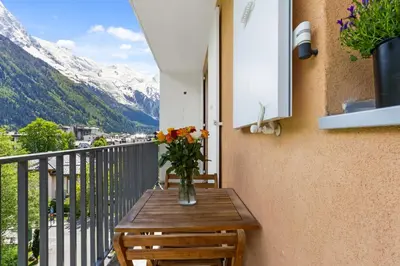 a vase of flowers on a table on a balcony at Apartment Le Panoramic in Chamonix-Mont-Blanc