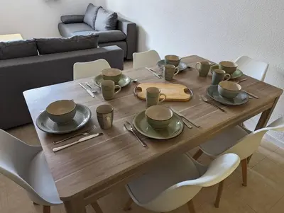 a wooden table with cups and plates on it at Central spacious flat with private parking in Chamonix-Mont-Blanc