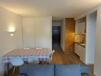 a living room and kitchen with a table and a couch at Central spacious flat with private parking in Chamonix-Mont-Blanc