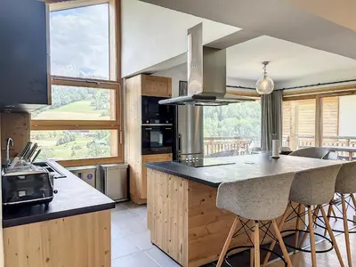 a kitchen with a island with bar stools at Chalet de Luxe 6 Chambres avec Piscine et Bien-Être à Combloux - FR-1-560-107 in Combloux