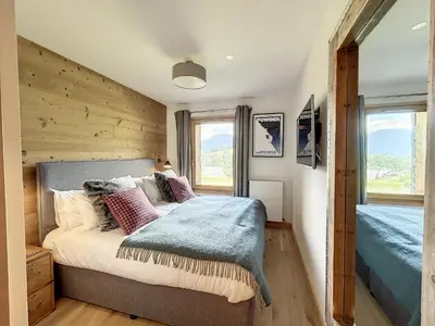 a bedroom with a bed and two windows at Chalet de Luxe 6 Chambres avec Piscine et Bien-Être à Combloux - FR-1-560-107 in Combloux