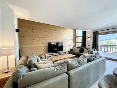 a living room with a large couch and a tv at Chalet de Luxe 6 Chambres avec Piscine et Bien-Être à Combloux - FR-1-560-107 in Combloux
