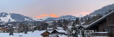 a snow covered village with a mountain in the background at Appartement standing face mont blanc piscine in Megève