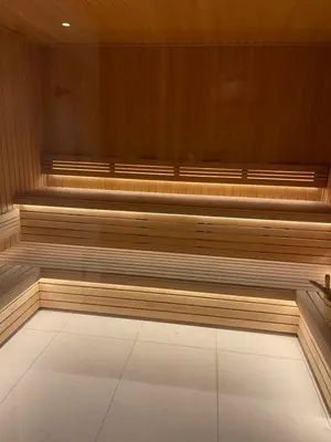 a sauna with wooden seats and a white floor at Appartement standing face mont blanc piscine in Megève