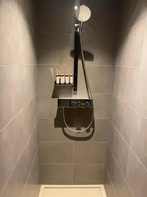a bathroom with a shower with a light on the wall at Appartement standing face mont blanc piscine in Megève