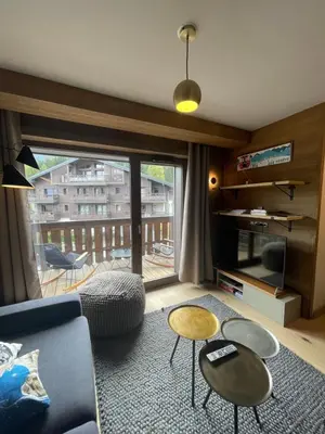 a living room with a couch and two tables at Appartement standing face mont blanc piscine in Megève