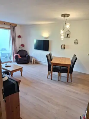 a living room with a wooden table and chairs at Très bel Appartement Lumineux à Samoëns in Samoëns