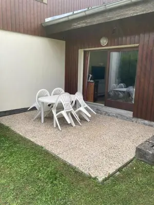 three white chairs and a table outside of a house at Très bel Appartement Lumineux à Samoëns in Samoëns