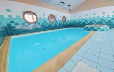 a large swimming pool with blue water in a bathroom at Très bel Appartement Lumineux à Samoëns in Samoëns