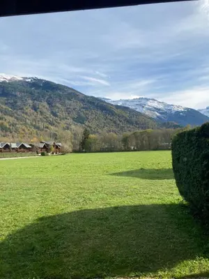 a large green field with mountains in the background at Très bel Appartement Lumineux à Samoëns in Samoëns