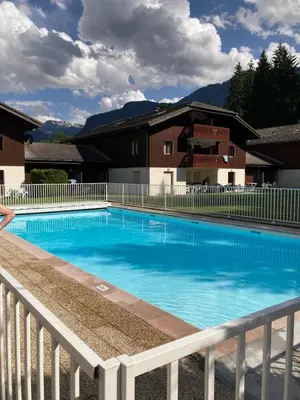 a large swimming pool in front of a house at Très bel Appartement Lumineux à Samoëns in Samoëns