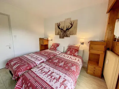 a bedroom with a bed with red comforter at Caribou Lodge in Chamonix-Mont-Blanc