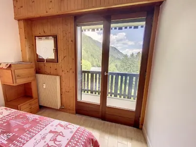 a bedroom with a large window with a view of a mountain at Caribou Lodge in Chamonix-Mont-Blanc