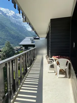 a balcony with a table and chairs and mountains at Caribou Lodge in Chamonix-Mont-Blanc