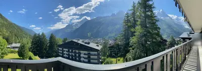 a balcony with a view of a town and mountains at Caribou Lodge in Chamonix-Mont-Blanc