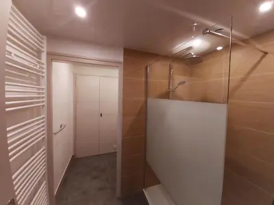 a bathroom with a walk in shower and a glass door at Chalet Monte-Pente in Megève