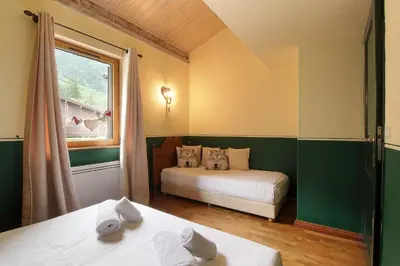 a room with two beds and a window and a bed at Clos des vorgeats 3 - Téléphérique, Terrain de Folf, Randonnée et Bus à la porte in Chamonix-Mont-Blanc
