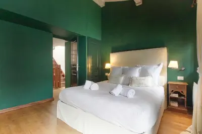 a bedroom with a large white bed with green walls at Clos des vorgeats 3 - Téléphérique, Terrain de Folf, Randonnée et Bus à la porte in Chamonix-Mont-Blanc