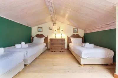 two beds in a room with green walls at Clos des vorgeats 3 - Téléphérique, Terrain de Folf, Randonnée et Bus à la porte in Chamonix-Mont-Blanc