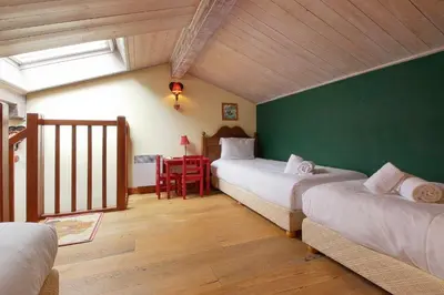 a bedroom with two beds and a green wall at Clos des vorgeats 3 - Téléphérique, Terrain de Folf, Randonnée et Bus à la porte in Chamonix-Mont-Blanc