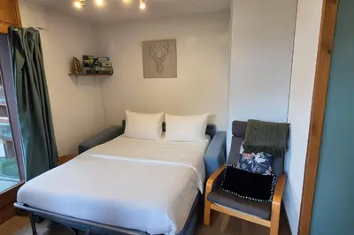 a small room with a bed and a chair at Appartement O'Contamines in Les Contamines-Montjoie